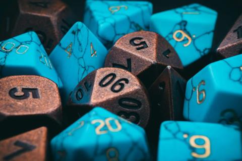 Turquoise and gold polyhedra dice with numbers.