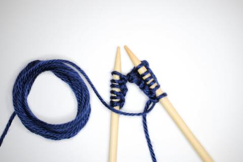 Two knitting needles and dark blue yarn