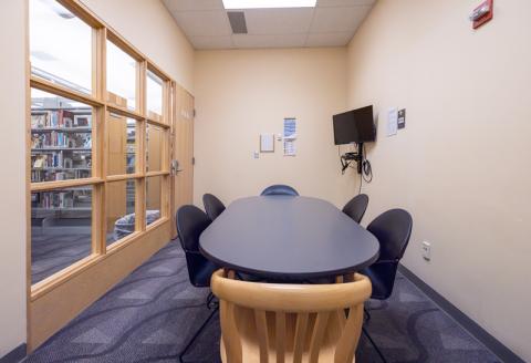 Oval table with chairs, TV and Blu-ray player