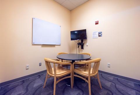 Small round table with chairs, TV and Blu-ray player