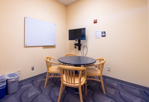 Small round table with chairs, TV and Blu-ray player