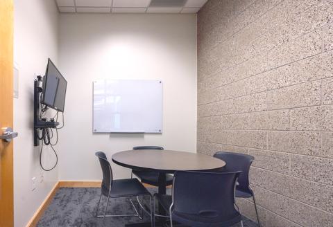 Small table with chairs, glass whiteboard, TV and Blu-ray player.