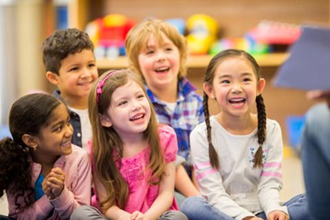 Diverse group of preschoolers sitting on floor listening to stories.