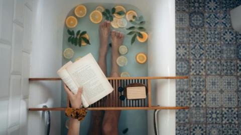 Person reading book in tub