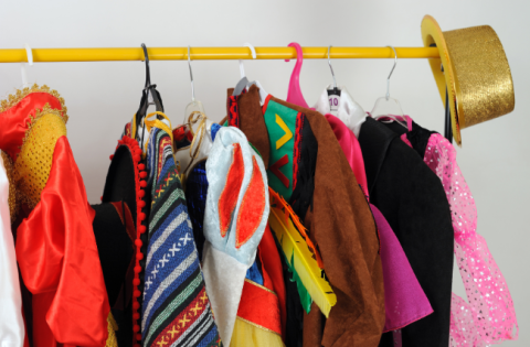 Costumes hanging on a clothes bar.