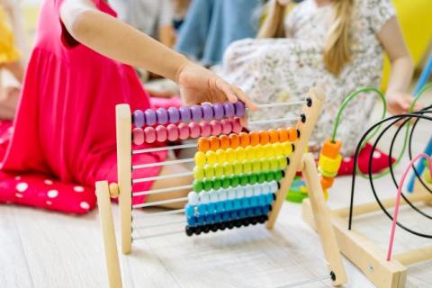 Young child playing with colorful abacus. 