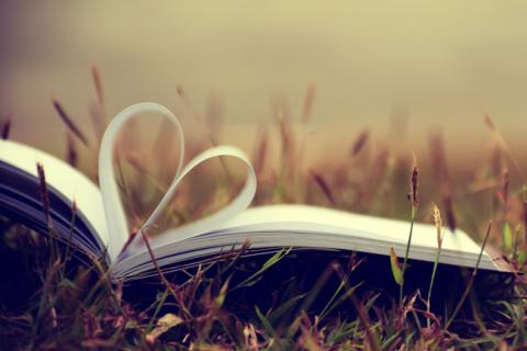 Open book with two pages curled to form a heart shape.