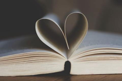 Open book with pages turned into a heart.