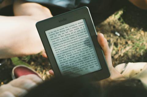 Image of a Kindle e-reader being held by a person.