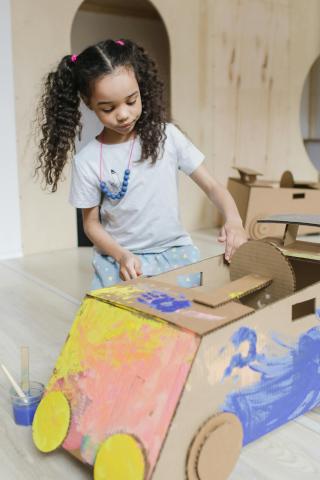 girl building cardboard car