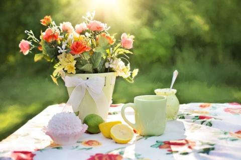 Table with flowers, cupcake, and lemonade.