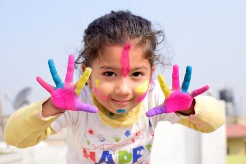 Young girl with paint on her hands and face