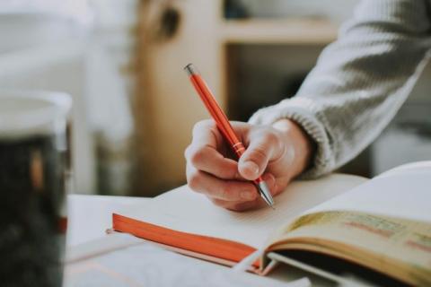 Person writing in notebook.