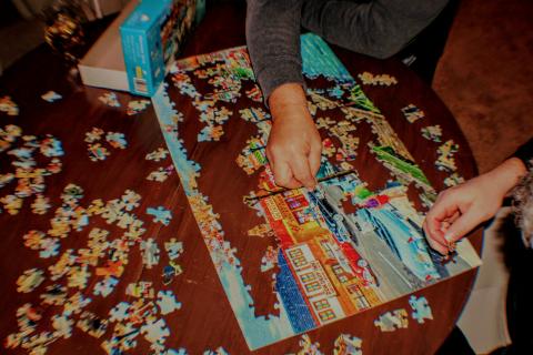 A person putting together a puzzle on a table