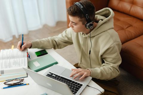 Teen boy listening to music while studying. 