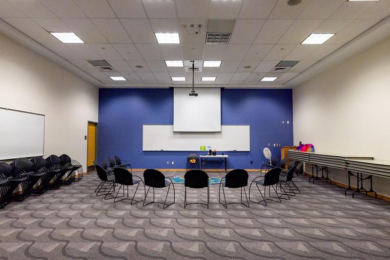 Small group of chairs facing projector screen and white board in Multipurpose Room L107 