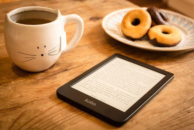 E-reader on table with coffee and donuts