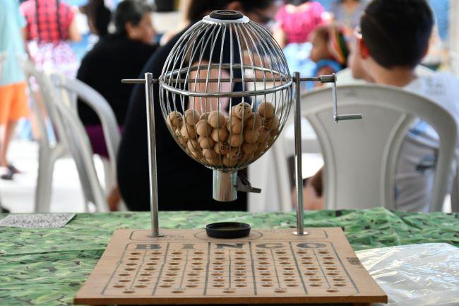 Bingo balls on table with families sitting behind it.