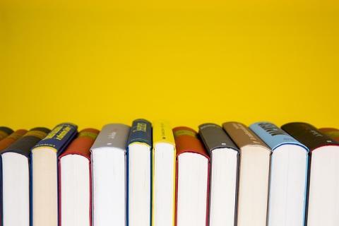 Books in a row with yellow background