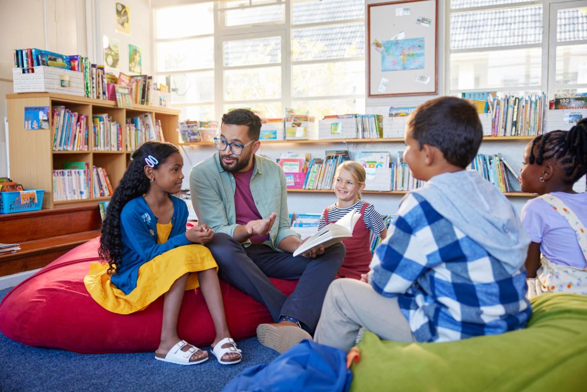 Male teacher reading books to students