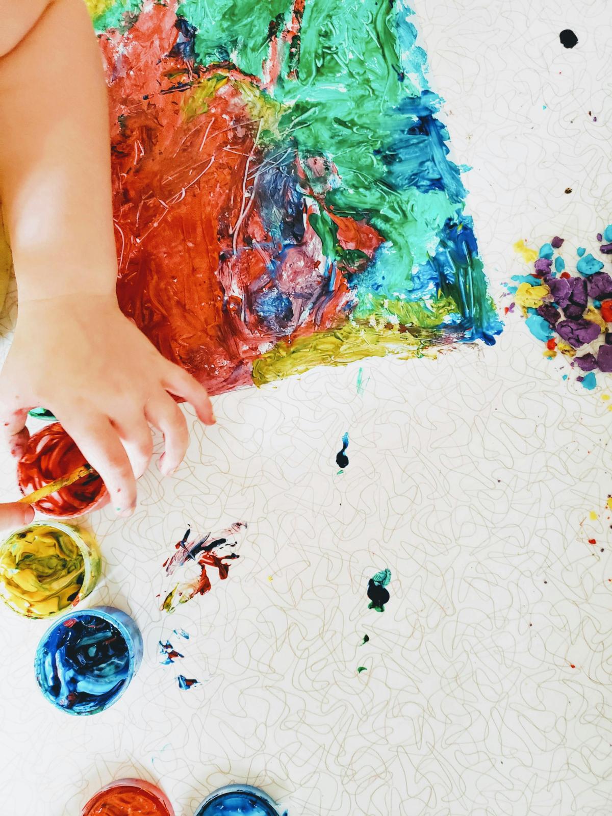 child's hand with messy paint