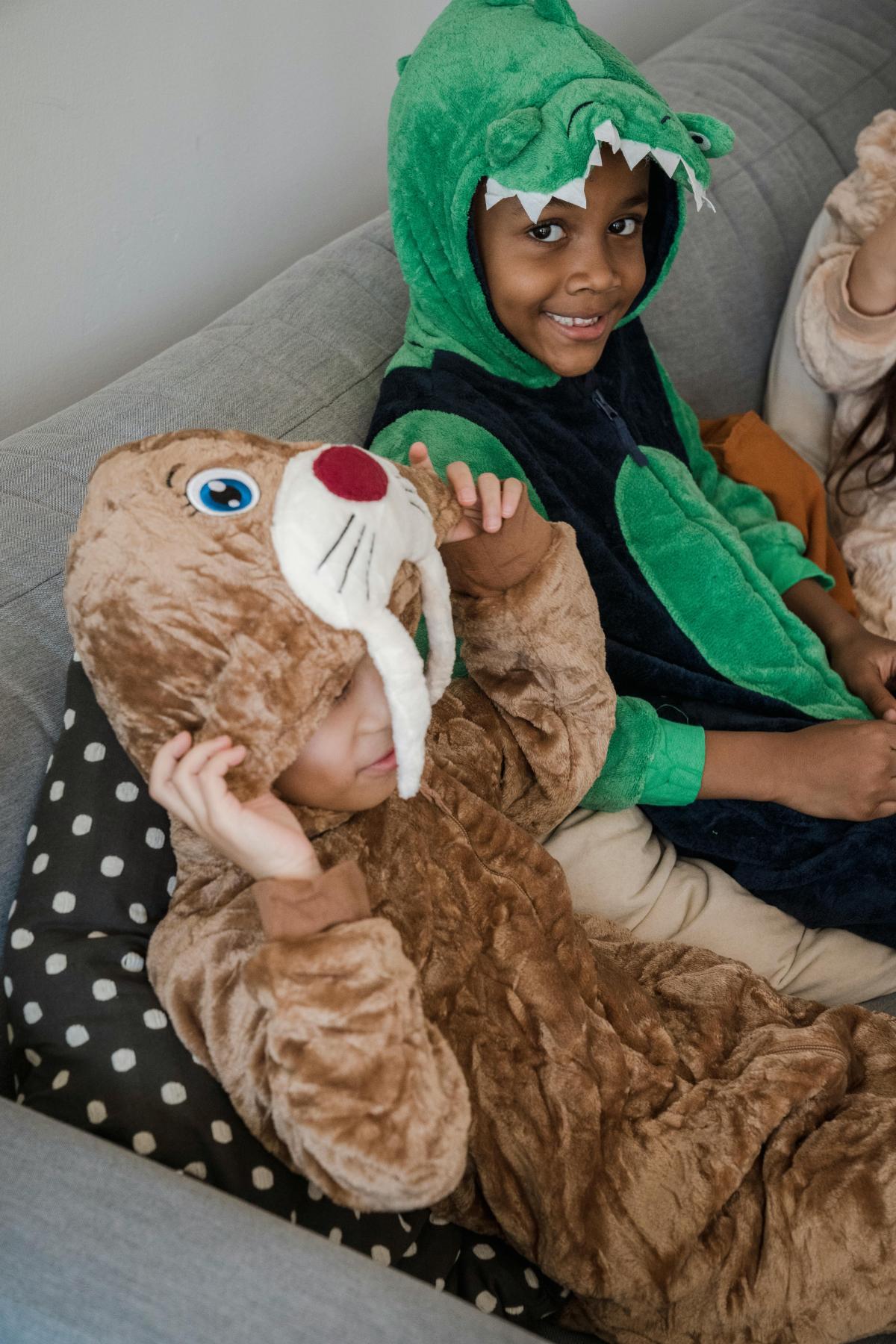 Kids sitting on couch in onesie costumes